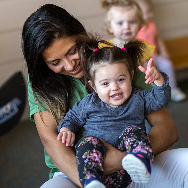 A teacher holding a little girl on her lap