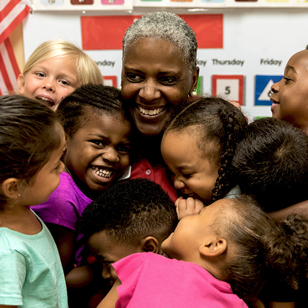 Teacher being hugged by a group of kids