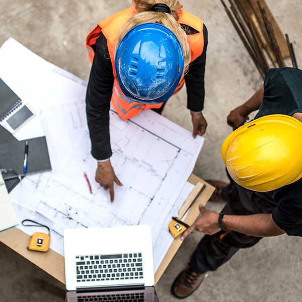 Workers at Construction Site Reviewing Blue Prints