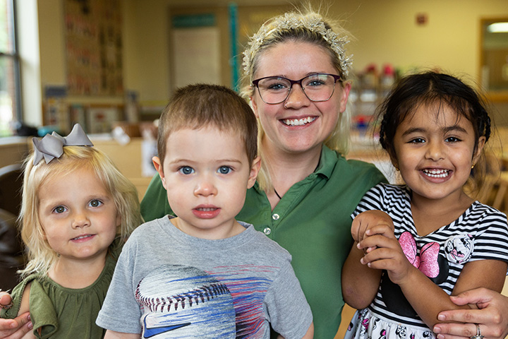 A teacher and three kids posing for a picture