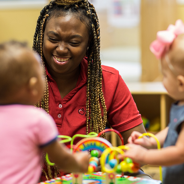 Teacher playing with two little girls 